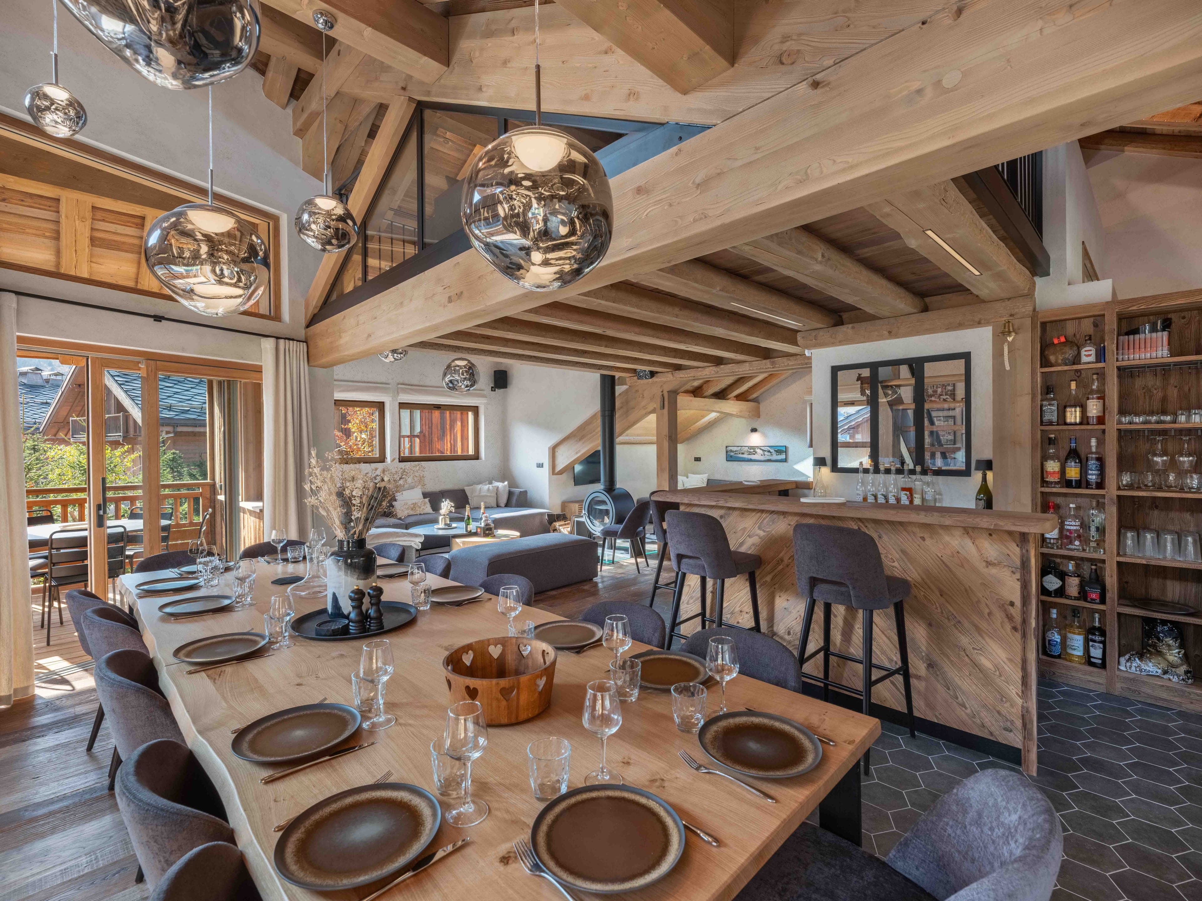 Dining table for 14 beneath oak beams, with the bar and kitchen beyond