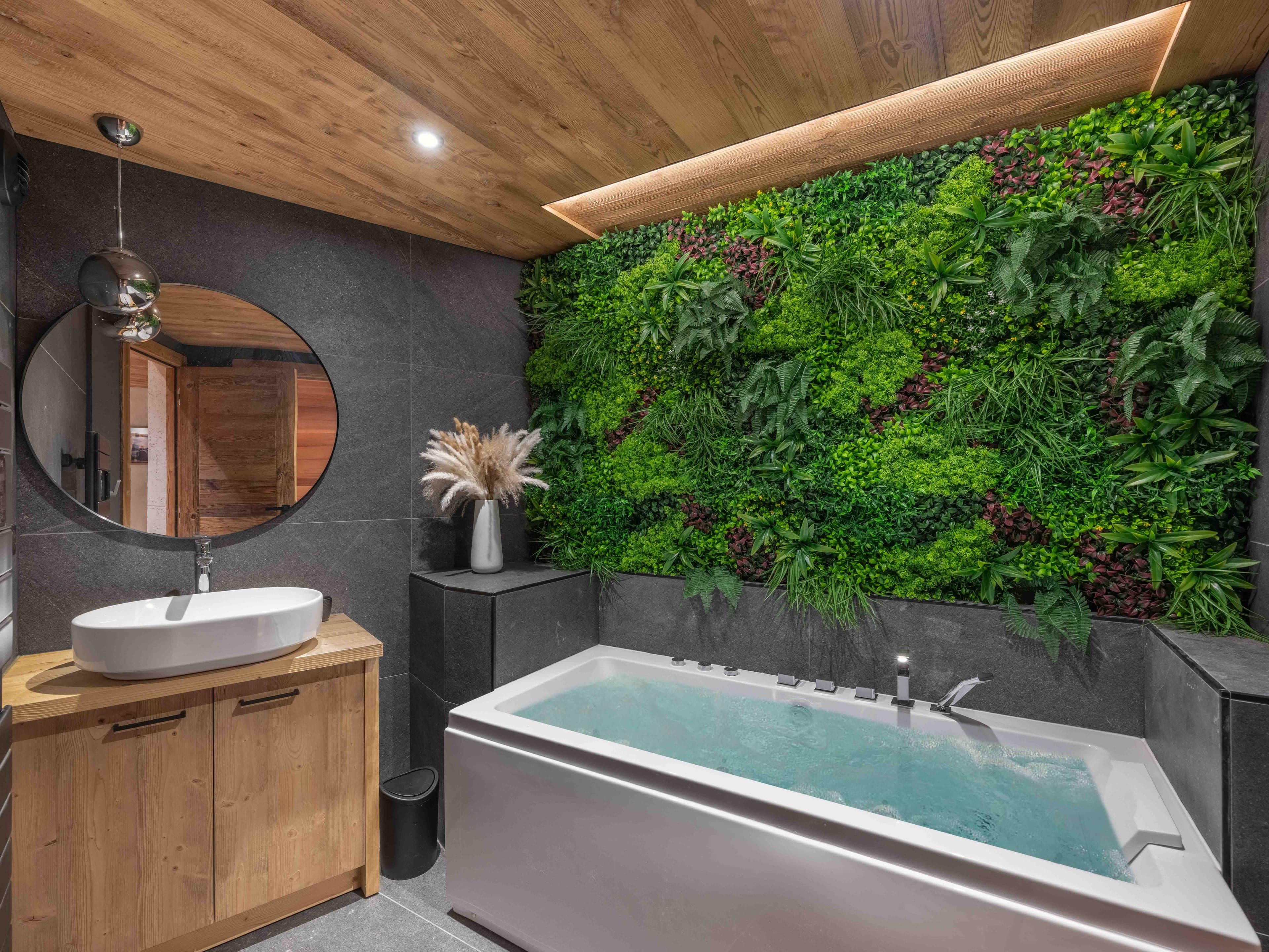 Wellness room with a balneo bath in front of a living green wall