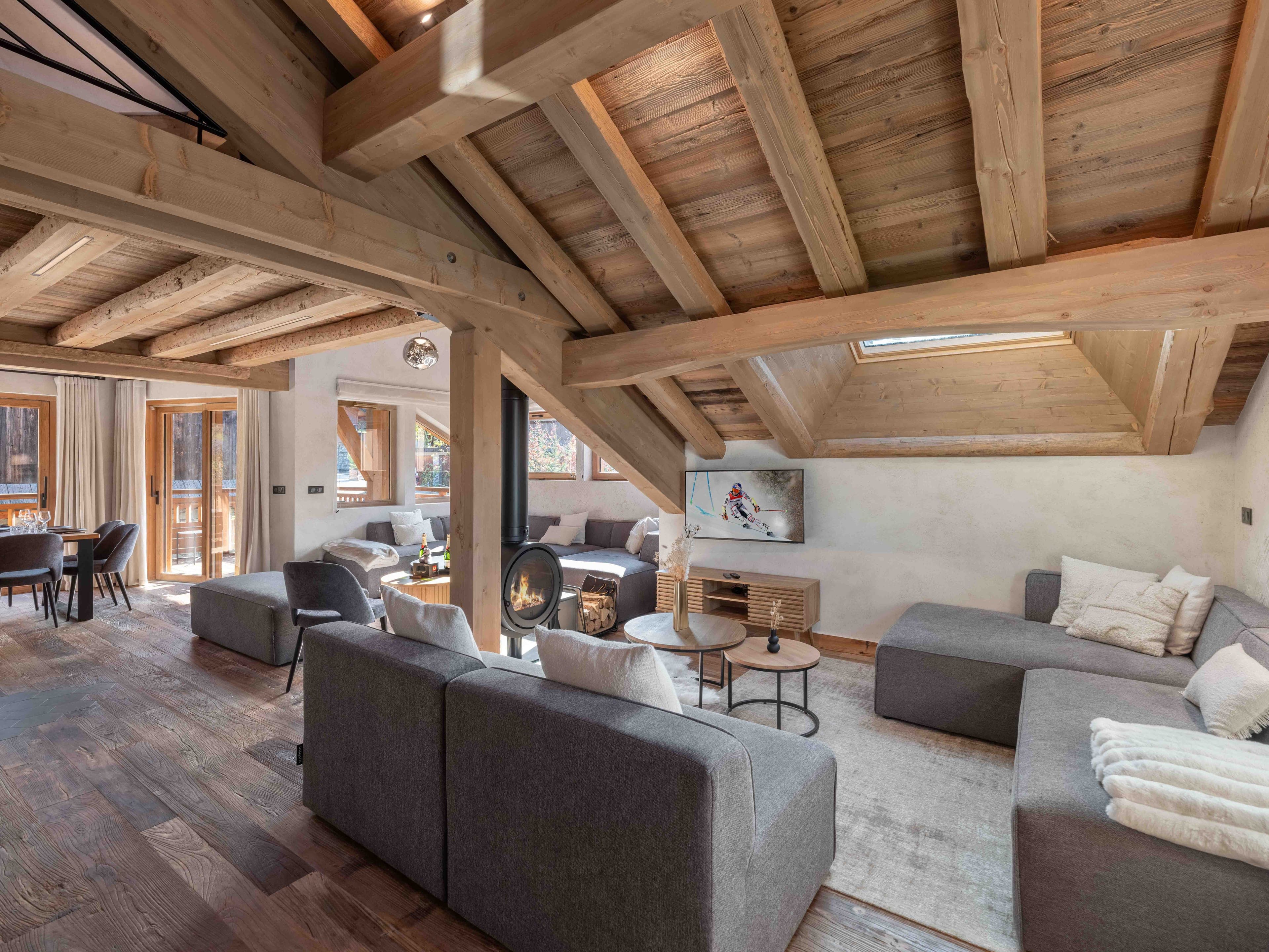 Living room under oak beams, with corner sofas around the round fireplace